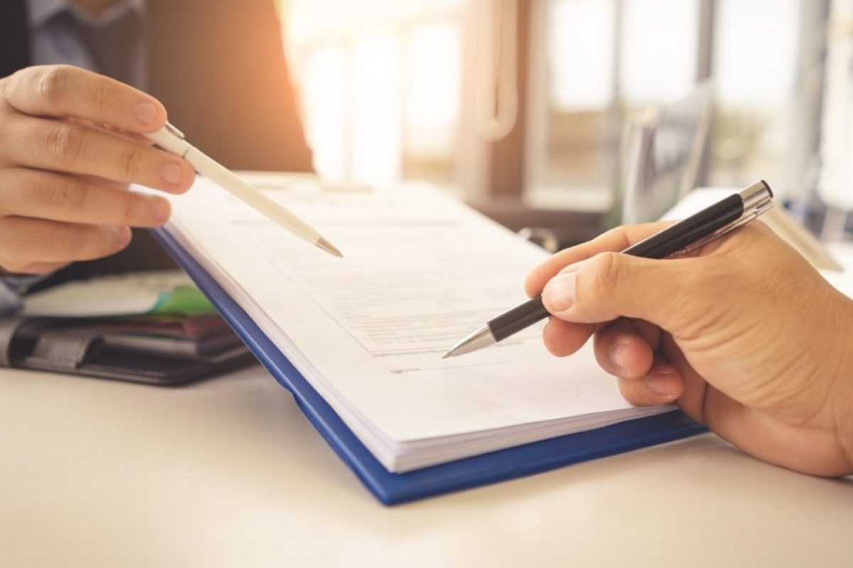 Advogado e cliente revisando contrato imobiliário com alienação fiduciária